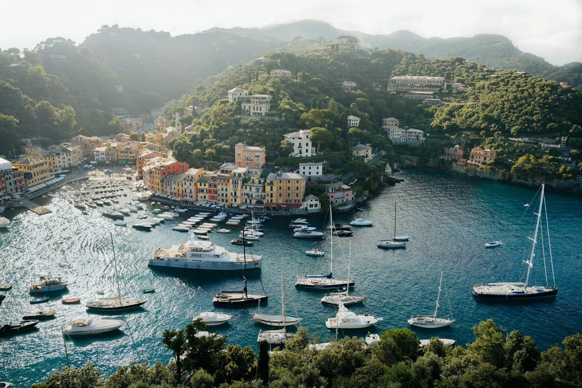 Portofino's yacht-filled harbour tucked into its green, misty headland on the Ligurian coast