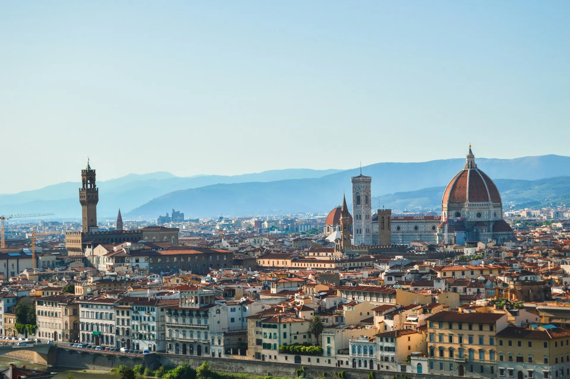 Florence from the hills — Brunelleschi's Duomo and the tower of Palazzo Vecchio above a sea of terracotta roofs