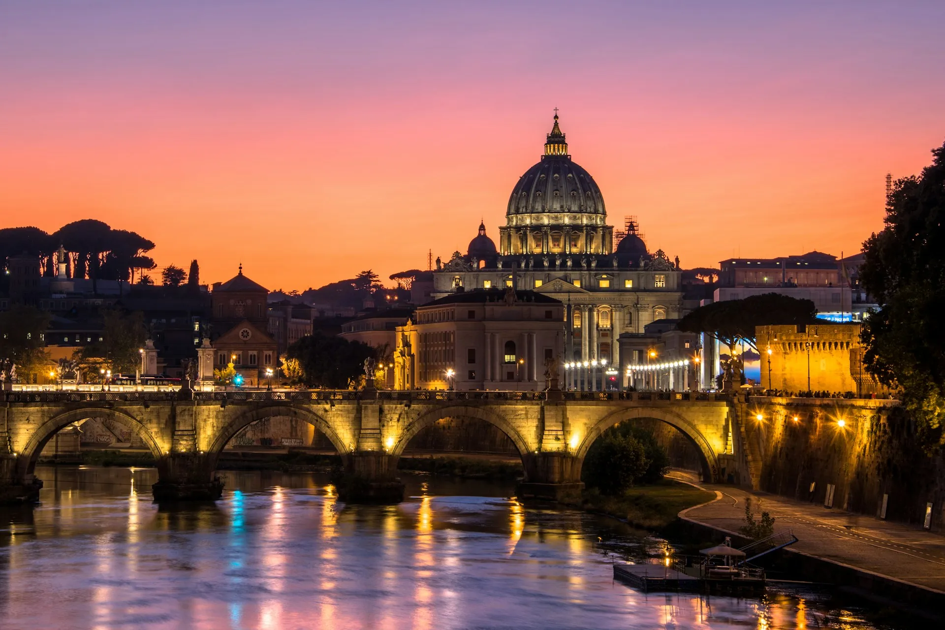 St Peter's Basilica lit against a burning sunset over the Tiber — a last look at Rome before home